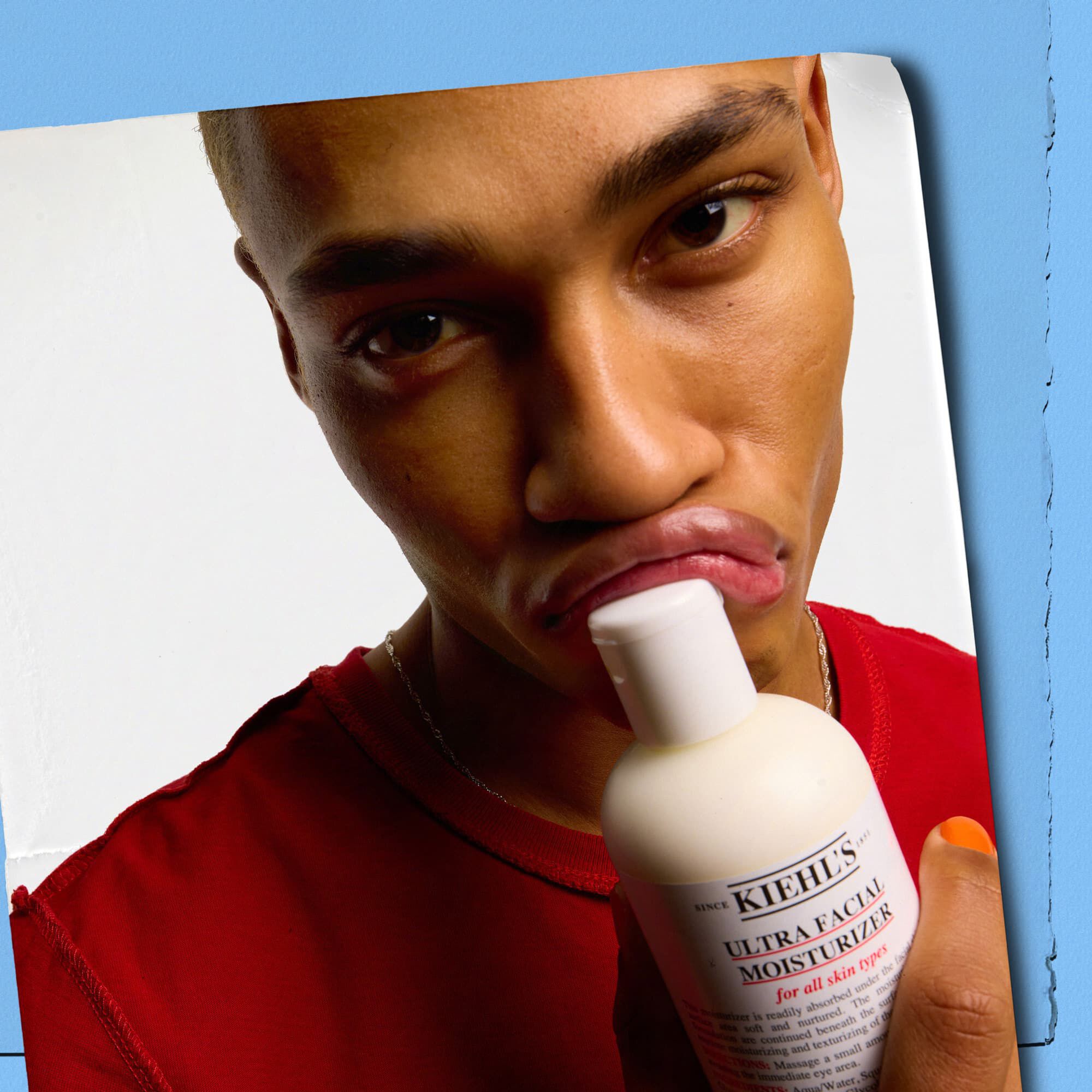 Model pritišće bočicu Kiehl's Ultra Facial Moisturizer uz usne