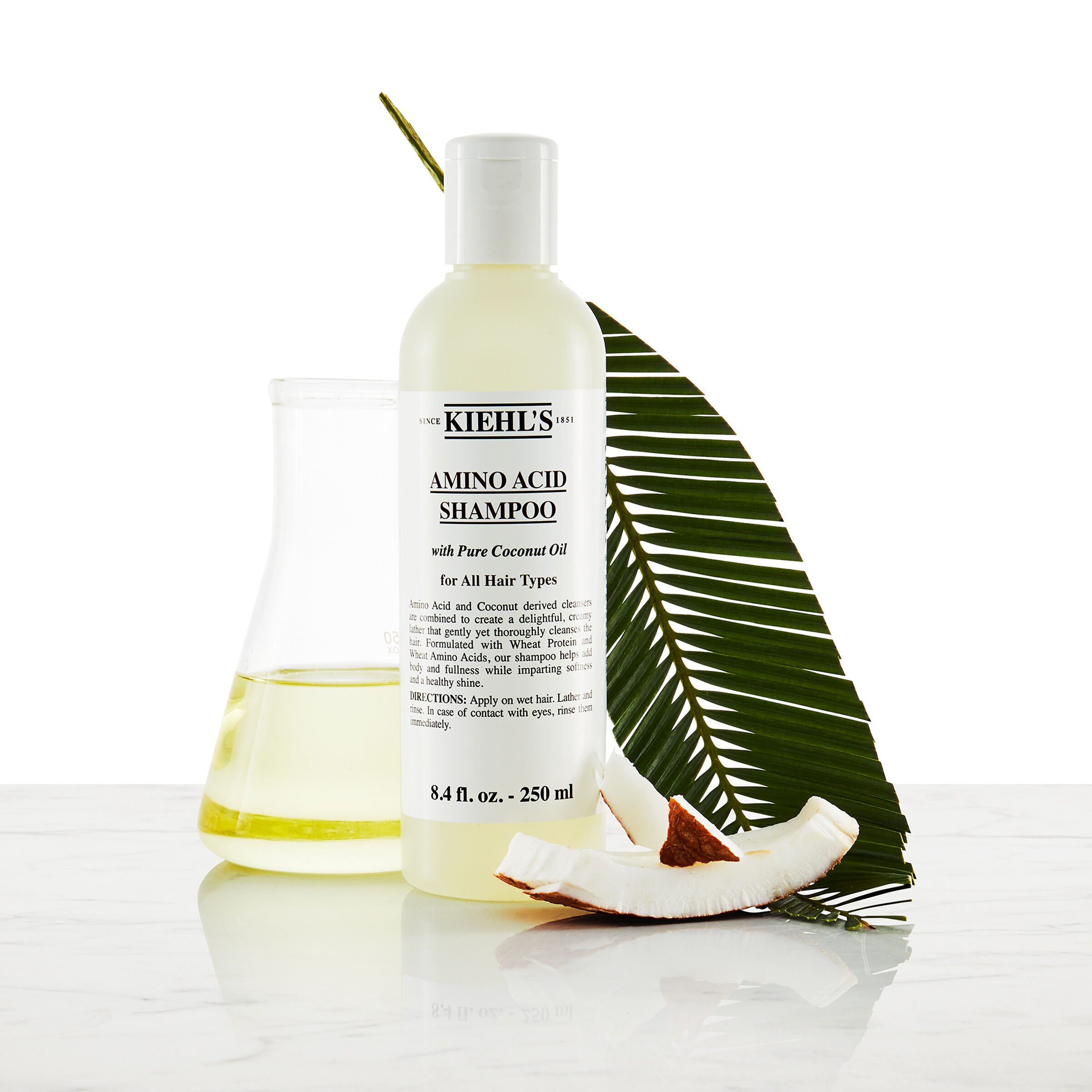 Model s brkovima i bočicom Kiehl's Amino Acid šampona