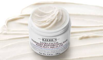 A jar of Kiehl's Ultra Facial Overnight Rehydrating Mask, with a creamy texture and a smooth, white backdrop. The jar is labeled prominently and showcases its contents.