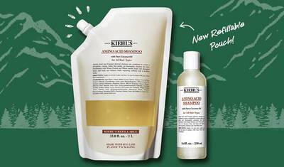 A promotional image showcasing Kiehl's Amino Acid Shampoo, featuring a refillable pouch and a smaller bottle. The background includes a green mountainous landscape, and there's a text label indicating "New Refillable Pouch".