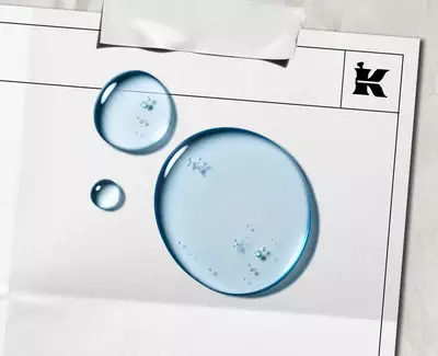 Plave tekuće kapljice predstavljaju α-Bisabolol na bijelom listu s crnim Kiehl's logom u kutu.