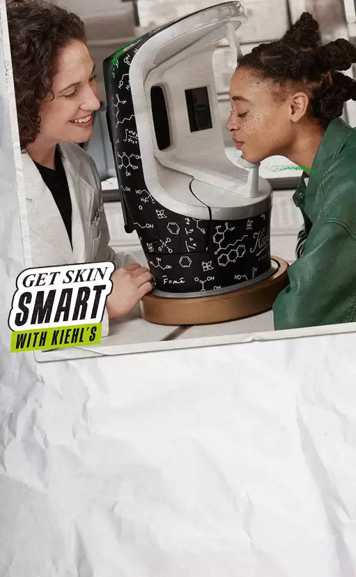 Dva lica se smiju dok istražuju kožne proizvode u modernom uređaju, s natpisom "Get Skin Smart with Kiehl's".